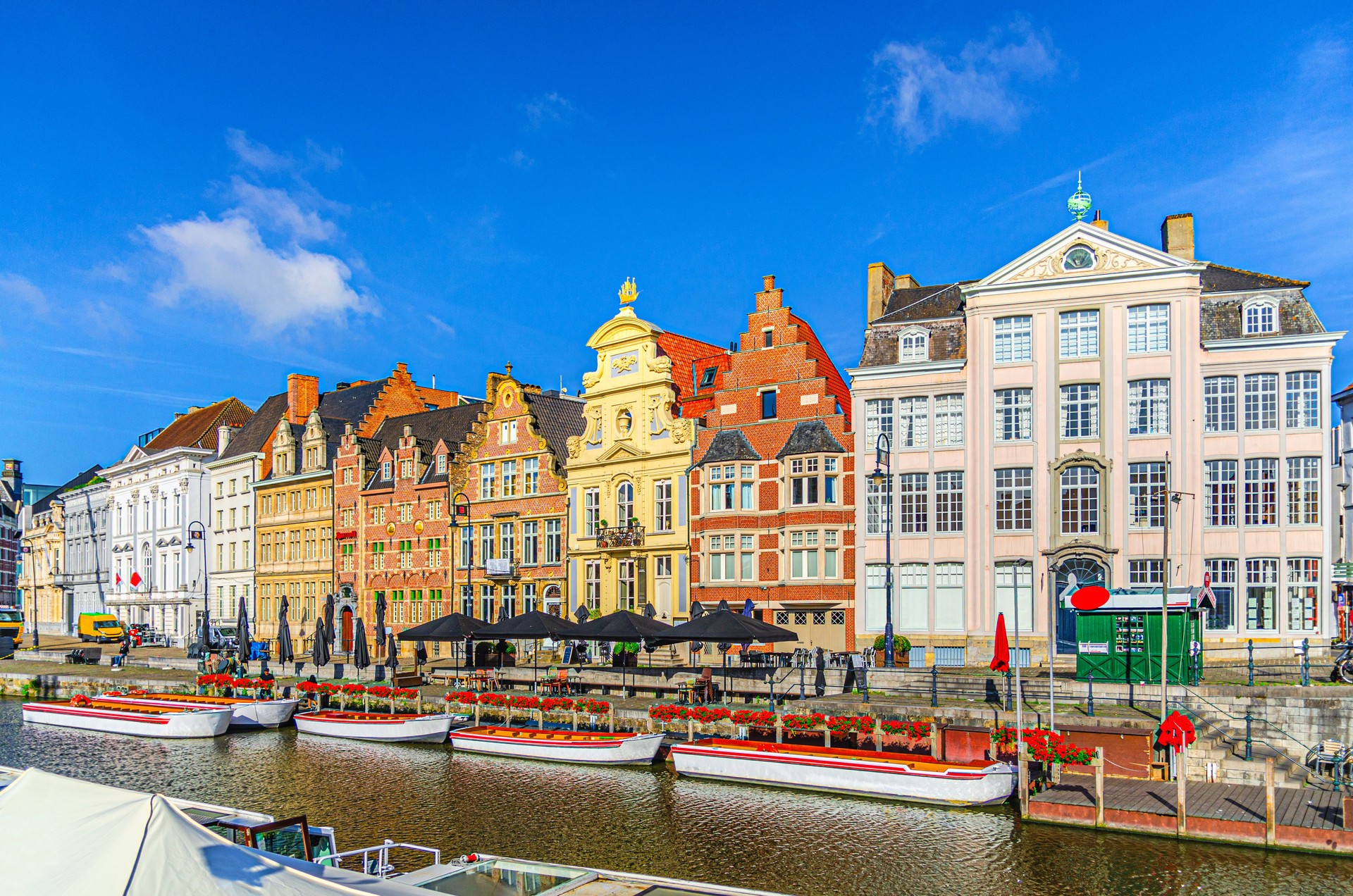 Ghent city historical center, tourists boats near Korenlei Corn Wheat Quay on Leie river bank, row of old colorful buildings on Lys river embankment, East Flanders province, Flemish Region, Belgium