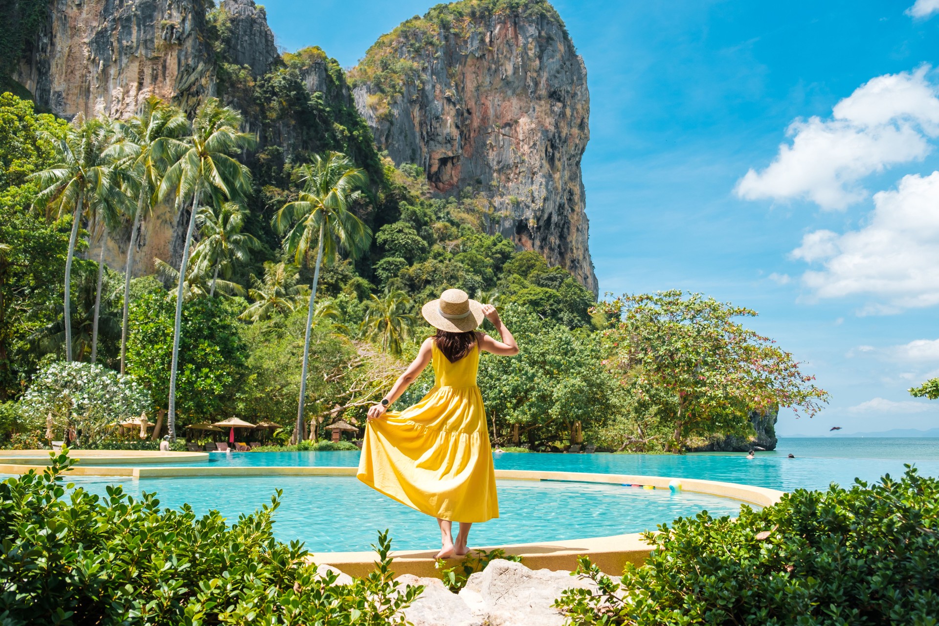 Woman tourist in yellow dress and hat traveling on Railay beach, Krabi, Thailand. vacation, travel, summer, Wanderlust and holiday concept